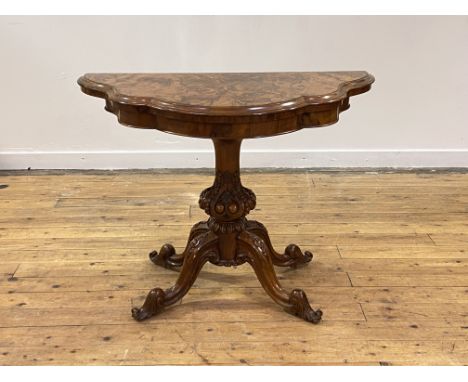 A Victorian figured walnut card table, the top, of serpentine outline, folding and revolving to reveal baize lined playing su