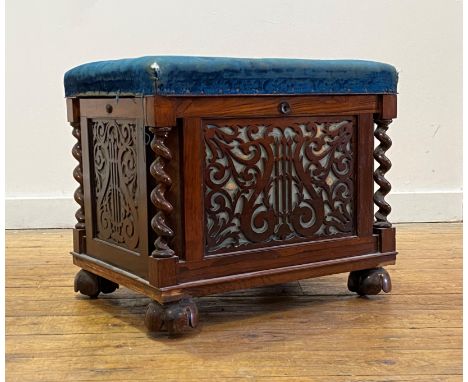 An early Victorian rosewood music stool, the worn blue velvet upholstered top lifting to an interior with spindle division, o