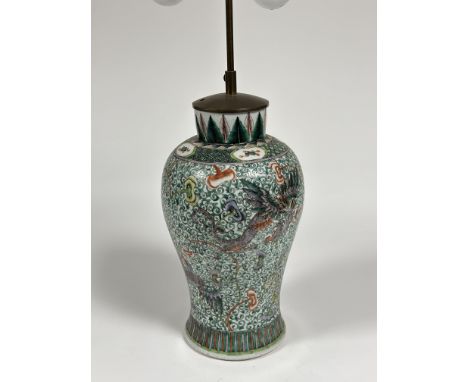 A Chinese famille verte porcelain vase of baluster form, mounted as a table lamp, decorated with winged dragons against a scr