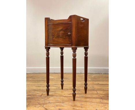 A late George III mahogany bow front night commode or bedside table, the tray top with pierced handle to each side, the door 