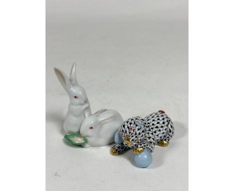 A Herend model of a puppy playing with a ball, in the black fishnet pattern, and a Herend group of two rabbits with an ear of