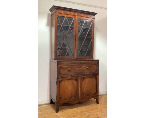 An early 19th century mahogany secretaire bookcase, the dentil cornice over a well figured frieze, the twin astragal glazed d