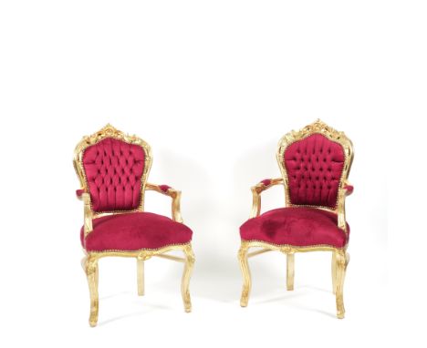 A PAIR OF GILT FRAMED OPEN ARMCHAIRS (2)With button back scarlett upholstery, 63cm wide; 107cm high