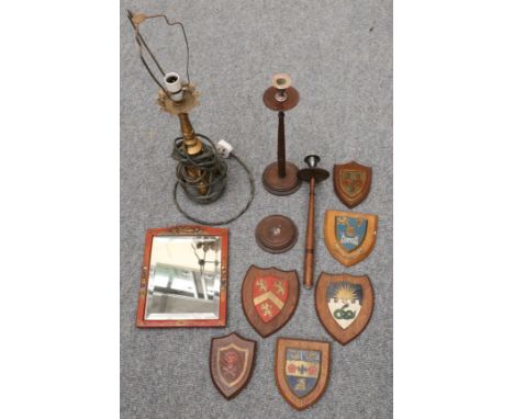 A pair of turned candlesticks, a lacquered framed mirror, six painted armorial shields and a gold painted metal lamp base 