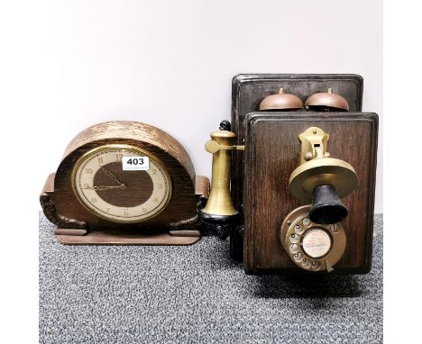 A wall mounted telephone and a vintage oak clock.