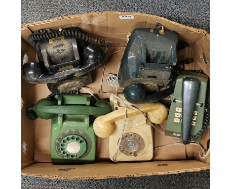A group of five vintage telephones.