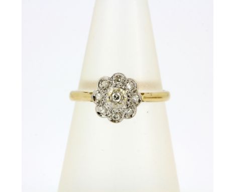 A hallmarked 18ct yellow and white gold diamond cluster ring, (N). Approx 2.8g.