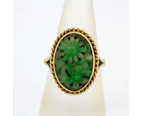 A hallmarked 9ct yellow gold and carved jade ring, (P.5). Approx 6g.