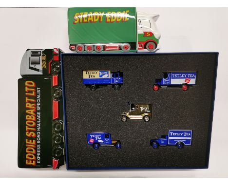 A boxed set of Tetley T diecast model vans and two ceramic money boxes.
