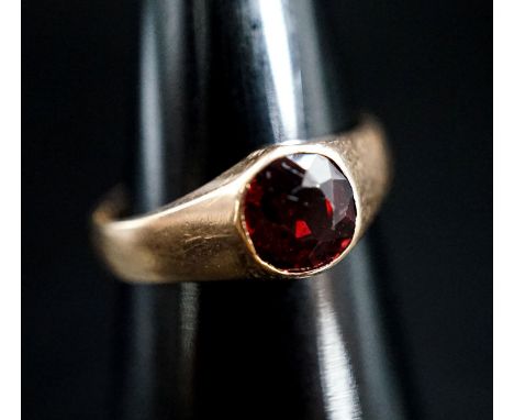 A yellow metal and garnet set ring, size N, gross 4.5 grams.