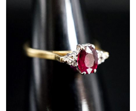 A  750 yellow metal, single stone oval cut ruby and six stone diamond chip set ring, size O, gross weight 2.7 rams.