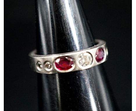 A white metal and gypsy set ruby and diamond set half hoop ring, size M, gross 6.1 grams.