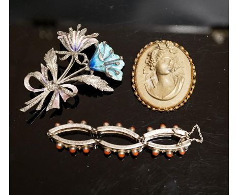 A 19th-century Lava cameo brooch, 49mm, a marcasite and enamel floral spray brooch and a coral mounted white metal bracelet.