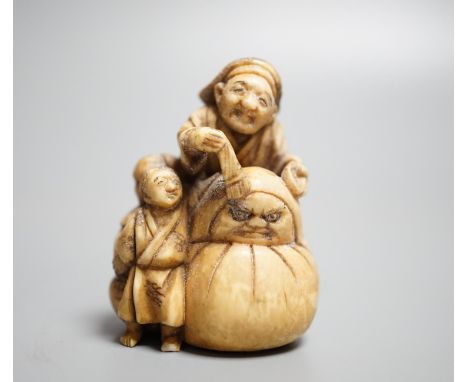 A Japanese ivory netsuke of an artisan and apprentice painting a Daruma doll, early 20th century,height 4cm