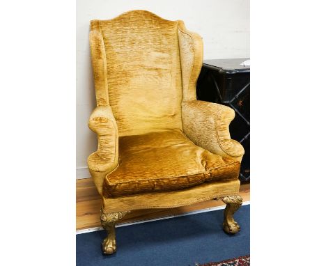 A Chippendale style gold velvet wing backed chair