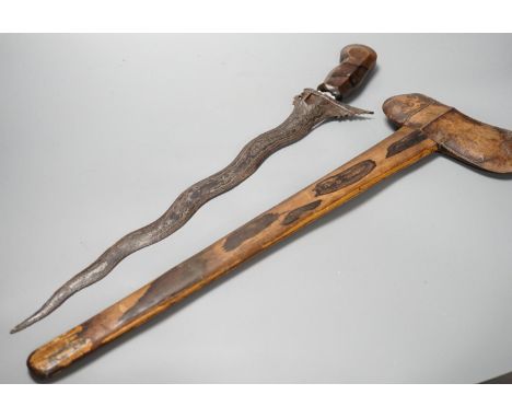 An Indonesian dagger kris, 19th century, earlier wavy black and silver-coloured watered blade, carved wooden handle and scabb