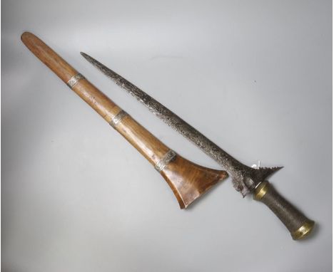 An Indonesian dagger kris, 19th century, earlier broad black and silver-coloured watered blade, brass mounted handle wound wi