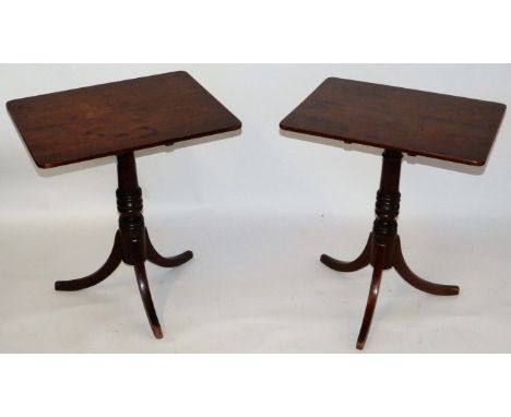 A pair of Regency mahogany tilt top tablesThe rectangular tops raised on turned columns with tripod bases, height 71cm, width