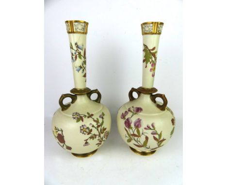 A pair of Royal Worcester blush ivory twin handled vasesOf bulbous form with cylindrical necks having reticulated rim, puce f