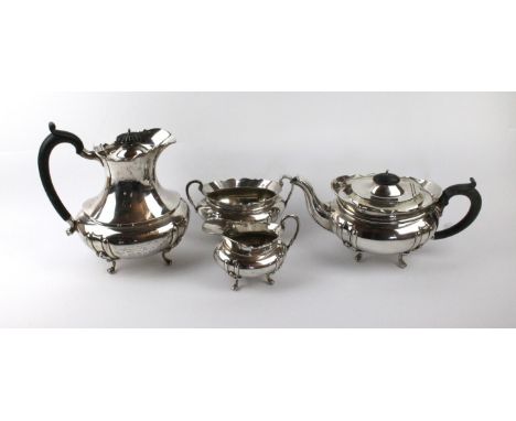A George V composite four piece tea service Comprising teapot, with ebonised handle and lid finial raised on four swept legs,