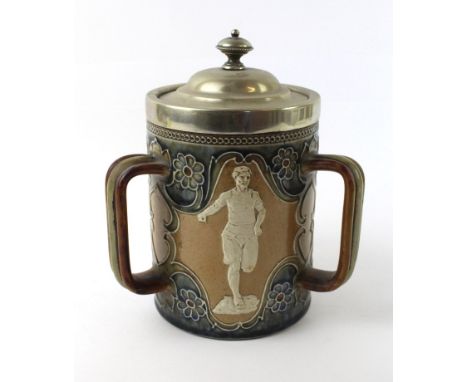 A Doulton Lambeth Artware lidded tygDecorated in relief with a runner, long jumper, and shot put thrower, with silver-plated 