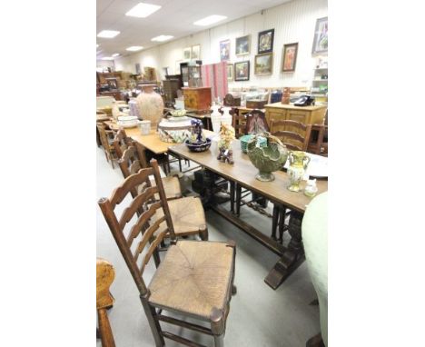 Oak Refectory Style Dining Table on carved cup and cover supports together with a Set of Six Oak Ladder Back Dining Chairs wi