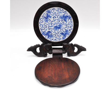 Depicting fish with flower opening to show a blue and white decor tile depicting temple lions, sculpture measures 32 x 28 cm.