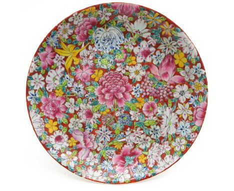Ruby ground with Famille Rose enamels in Mille Fleur decor, 33 cm. in diameter, small chip on rim.