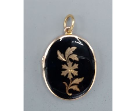 An 18ct gold and enamel locket of oval form with suspension ring, 11.1gms, 3cms x 2.5cms 