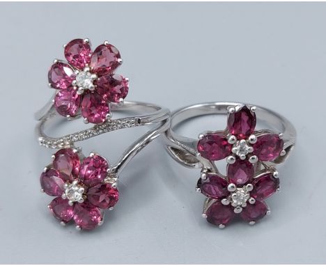 A 925 silver dress ring in the form of two flower heads set with amethyst together with another similar silver stone set ring