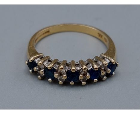 An 18ct gold band ring set with Diamonds and Sapphires, claw set, 3.9gms, ring size O 