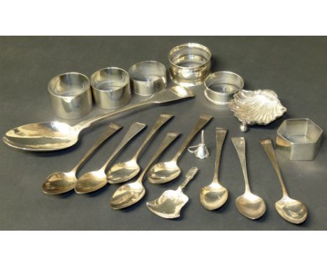 Eight silver tea spoons, caddy spoon, seven napkin rings, serving spoon, miniature funnel, shell dish Condition reports are n