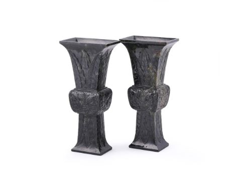 A pair of Chinese spinach jade vases, gu, of square section, the flared necks and feet carved with overlapping leaves, and th