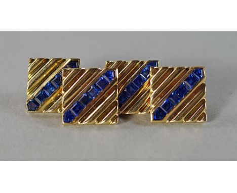A pair of sapphire set gentleman's cufflinks, the unmarked yellow metal links of square ribbed form, with a diagonal row of s