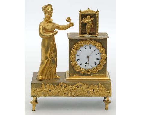 Kleine Empire-Pendule. Feuervergoldete Bronze. Rechteckiger Sockel auf vier Füßen (einmal unpatiniert), vollplastischer Aufsa