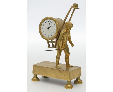 Kleine Empire-Pendule. Feuervergoldete Bronze. Rechteckiger Sockel auf vier Füßen, vollplastischer Aufsatz in Form eines Baue