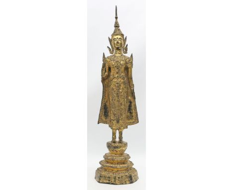 Stehender Buddha Shakyamuni. Bronze, über Schwarzlack vergoldet und reich reliefiert. Auf mehrstufigem Sockel stehend dargest