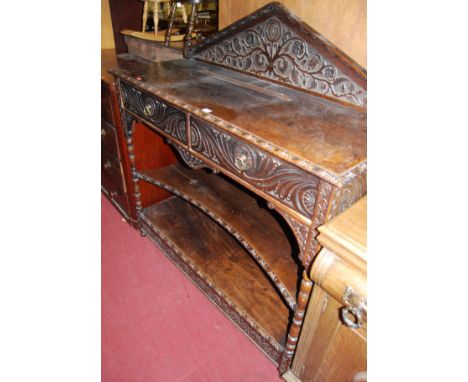 A late 19th century heavily carved oak ledgeback buffet whatnot, having twin frieze drawers over central shelf to lower platf