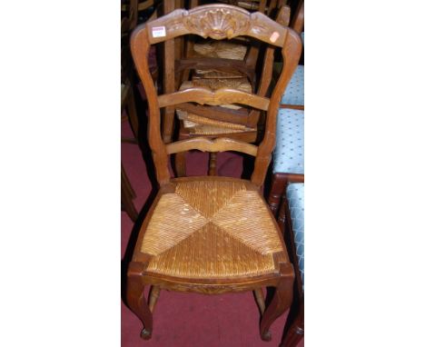 A set of six early 20th century provincial French oak ladder back rush seat dining chairs