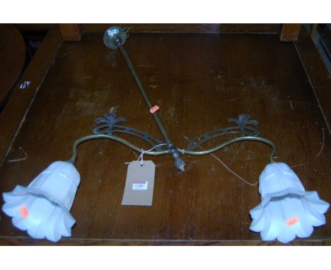 An Art Nouveau brass twin branch hanging ceiling light, having milk glass petal shades, drop 64cm