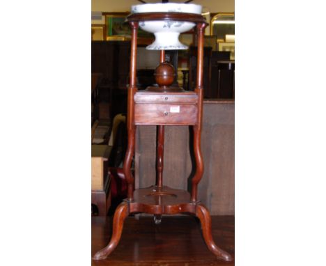 A 19th century mahogany circular three-tier wash stand, having ceramic bowl inset over two central drawers to shaped platform