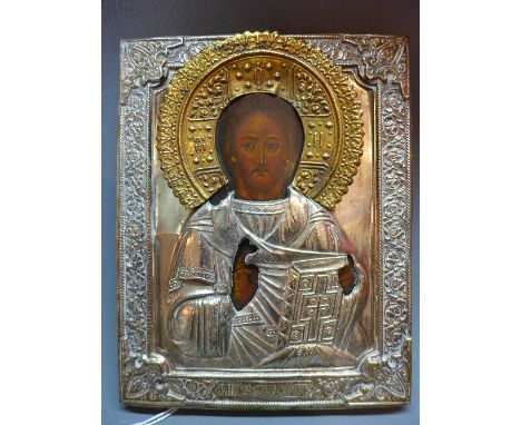 A Russian icon depicting Christ Pantocrator, painted wooden panel with repousse embossed white model oklad, 22cm x 18cm
