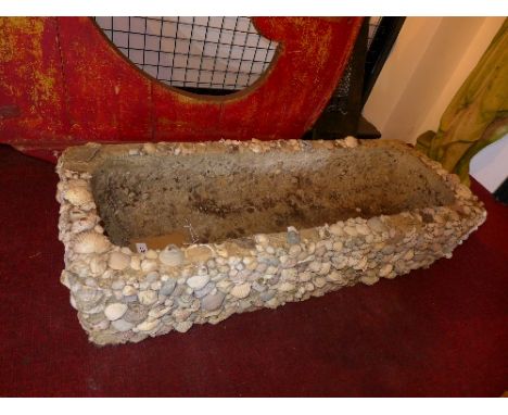 A large stone planter set with sea shells