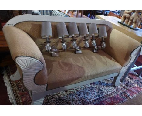 En early 20th Century Regency style two seater sofa with canvas upholstery raised on scroll legs