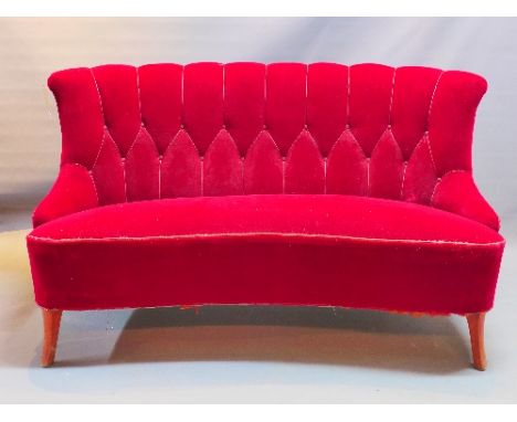 A 20th Century curved back three seater sofa with red button back velour upholstery