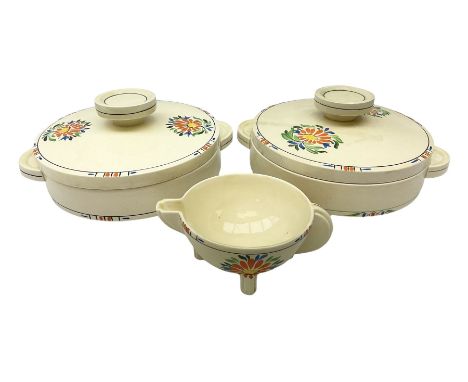 Two A J Wilkinson Honeyglaze Odilon shaped tureens and covers, and a matching jug, decorated with an orange floral pattern 