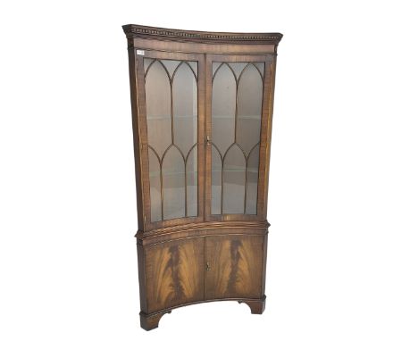 Bevan Funnell Reprodux - mahogany concave corner display cabinet, the moulded and dentil cornice over two astragal glazed doo