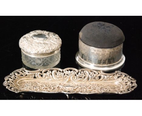 An Edwardian hallmarked silver circular combined ring box and pin cushion, the domed hinged cover opening to reveal a silk an
