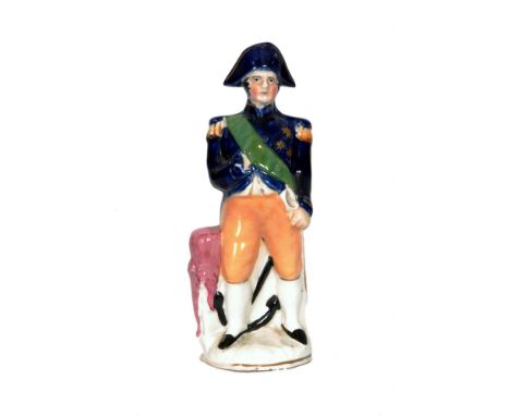 A 19th Century Staffordshire open base figure of Nelson stood dressed in a blue and orange naval uniform with a green sash an