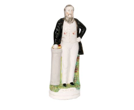 A 19th Century Staffordshire portrait figure of Swight Lynam Moody, he dressed in a black overcoat with one hand on his hip a